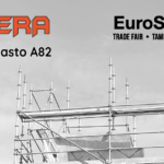 Mustavalkoinen kuva rakennustelineistä talon katon tasalla. Vasemmalla yläreunassa on Pateran oranssi logo ja teksti "Halli A, Osasto A82" ja oikealla yläkulmassa EuroSafety-tapahtuman logo minkä alla lukee pienemmällä "TRADE FAIR • TAMPERE • FINLAND"
